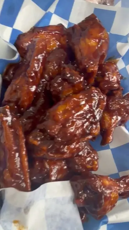 Saucy bone-in wings on blue-and-white check paper